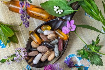Herbal supplements and vitamins on a wooden spoon