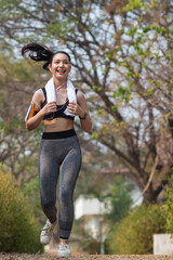 Beautiful Young Asia Woman Run Alone In The Park Because Run Makes Her Healthier And Fitter. Beautiful Asian Woman Smiling Happy While Run In The Park. Beautiful Young Asia Woman Jogging Alone