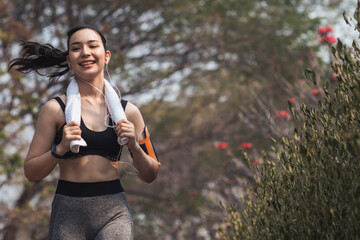 Beautiful Young Asia Woman Run Alone In The Park Because Run Makes Her Healthier And Fitter. Beautiful Asian Woman Smiling Happy While Run In The Park. Beautiful Young Asia Woman Jogging Alone