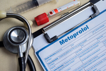 Concept of Metoprolol write on clipboard isolated on Wooden Table.