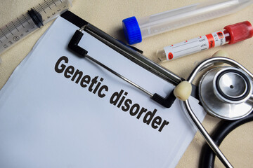 Concept of Genetic disorder write on clipboard isolated on Wooden Table. stethoscope and...