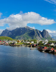 Lofoten Islands showcase stunning scenery with traditional wooden houses by the water, surrounded by dramatic mountains. Lofoten Norway