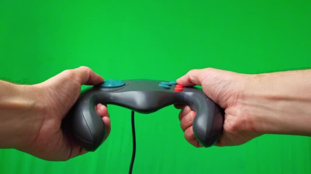 A close-up shot of a hand operating a vintage, grey trackball game controller with red buttons against a clean background. The fingers are manipulating the trackball and pressing buttons