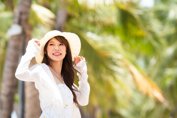 Asian woman enjoying travel and relaxation on a beautiful sunny day at the beach. 