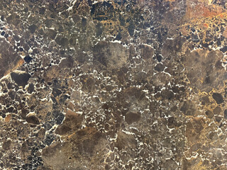 Close up photo of natural brown marble with random grunge and dirt pattern suitable for wall finishes or floor finishes. Luxurious dark brown feel. Seamless minerals background texture.
