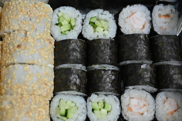 Sushi Rolls in Takeout Box, Street Food Sushi in Paper Box – Close View, Takeaway Sushi Rolls – Close-Up Shot, Japanese Street Food – Sushi Rolls in Cardboard Box, Fresh Sushi Takeout – Macro