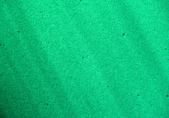 Background of porous foam rubber. Green foam rubber. Packaging material.