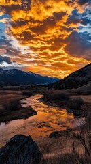 Morning light illuminates rugged mountains in gold, with clouds in motion. Vertical.