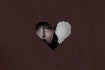 Mysterious gaze through heart-shaped cutout reveals emotions during quiet contemplation