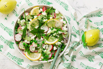 Spring Pea salad with radishes, feta  and mint. in ceramic bowl. selective focus
