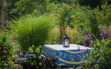 A beautiful French tablecloth perfectly matches the little lime hydrangeas surrounding this patio along with Cardinal Vine encircling the arbor 