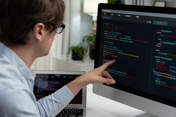 IT developer selecting by point on coding online software development information on pc comparing...