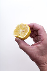 Close-up of a hand squeezing a fresh lemon, capturing the motion of juice droplets and the texture of citrus in a dynamic and refreshing moment.