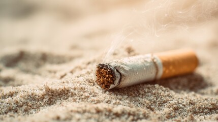Burnt cigarette butt lying on sand