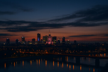 Naklejka premium Vista nocturna de ciudad moderna iluminada al anochecer 