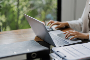 Business administrator reviewing financial reports and marketing analysis for company sales growth...