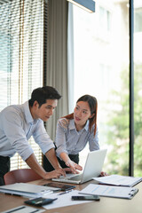 Office mentor with guidance from supervisor coaching a new intern on daily business tasks