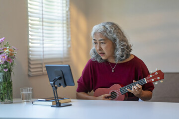 senior woman practices her musical skills at home