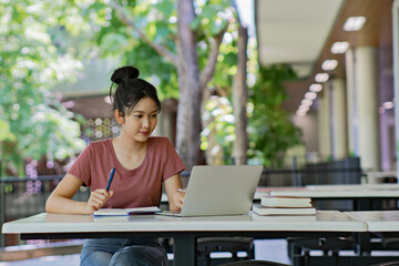 Young university student woman using laptop doing assays research