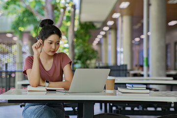 Young university student woman using laptop doing assays research