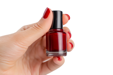 hand gently holding bottle of red nail polish  isolated on white background
