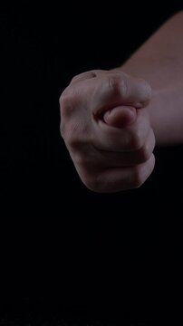 man's hand delicately presents a ripe fig emphasizing its texture and color against a dark background. The focus highlights the fruit's natural beauty and freshness.