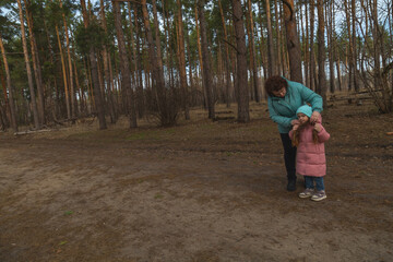 Grandmother and granddaughter walking in the forest
