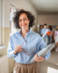 mature female teacher walk confidently at school hallway with handbag