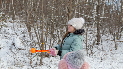 Little girls with her grandfather walk in a snowy forest, have fun together