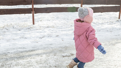 Little girls walking in park on snowy winter day
