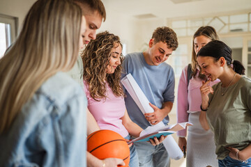 group of students study together from notebook on the school hallway