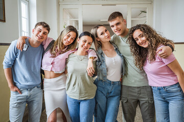 Portrait of hugged happy high school friends on school hallway