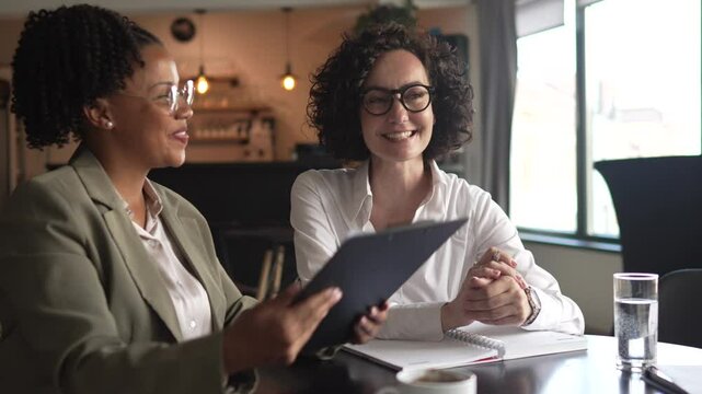 two multicultural businesswoman colleagues read and analysis document