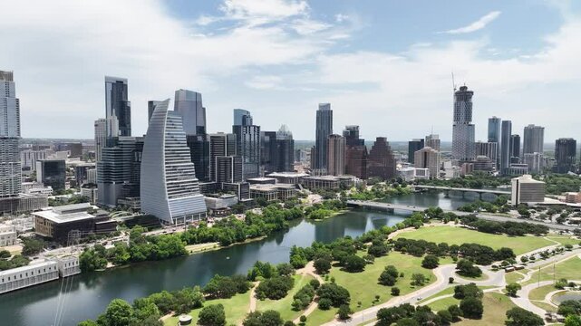 Vibrant daytime view: Austin downtown, Lady Bird Lake. Green park, running people, kayakers. Iconic city buildings, busy traffic.