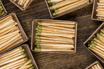 wooden matches with green grey poured into cardboard boxes , the green head of a wooden match laid out in cardboard boxes