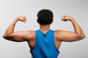 Young latino athlete showing muscle growth and progress in fitness