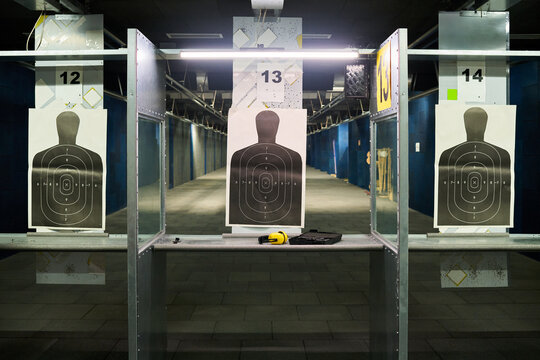 Indoor shooting range featuring targets on multiple lanes for practicing shooting skills Advanced shooting equipment is visible in the setup