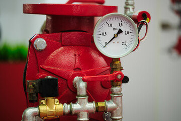 Stainless steel pipe with a white pressure gauge on it as part of a fire protection system