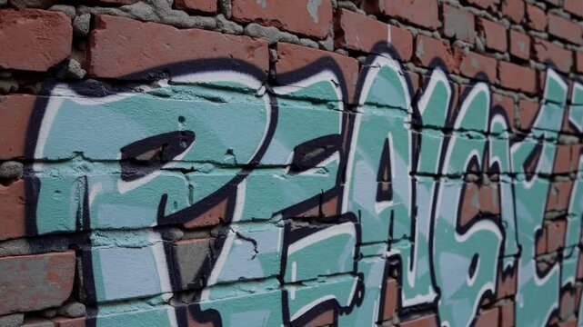 Peace graffiti painted in bold letters on old red brick wall

