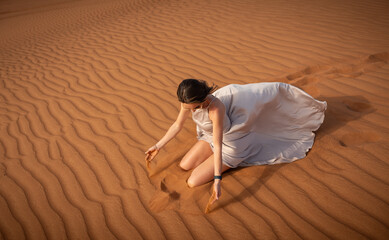 Beautiful girls in a beautiful flowing dress in desert condition