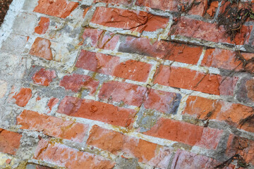 Close-up detail of weathered red brick wall texture showing aged masonry craftsmanship and natural...