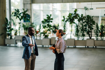 Businesspeople discussing strategy in modern office lobby