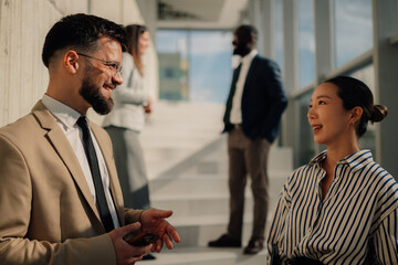 Business people talking during informal meeting in office hallway