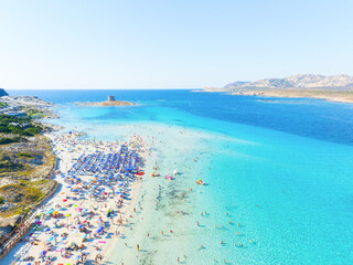 Beach La Pelosa, Sardinia, Italy. Summer vacation and rest. Beach, people and umbrellas. Top view from drone at the beach and azure sea. Background, wallpaper, postcards.