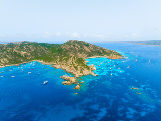 Island in the middle of the sea. Drone view of a yachts, boats and island. Vacationing people. North-eastern Sardinia, Maddalena Archipelago. Vacation and holidays. Summer time for sea travel.