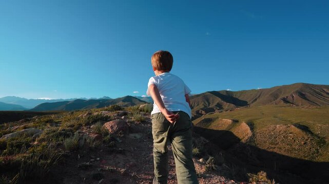 Child tourist walking on mountain path nature activity, slow motion