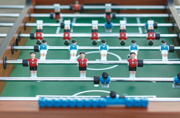 Close-up view of a foosball table with red and blue teams ready to play. Fun and competitive tabletop soccer game, perfect for recreation and entertainment.