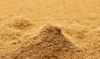Cumin seeds pile ground, caraway powder background, side view	