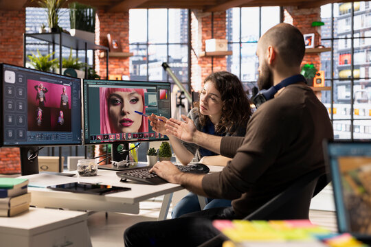 Man and woman creative team using AI to generate image models, operating an editing software to enhance digital materials and create quality content. AI assistant with photo retouching.