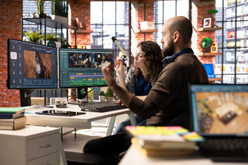 Video editors couple working as a team for a freelance video shoot, editing and mixing video clips...